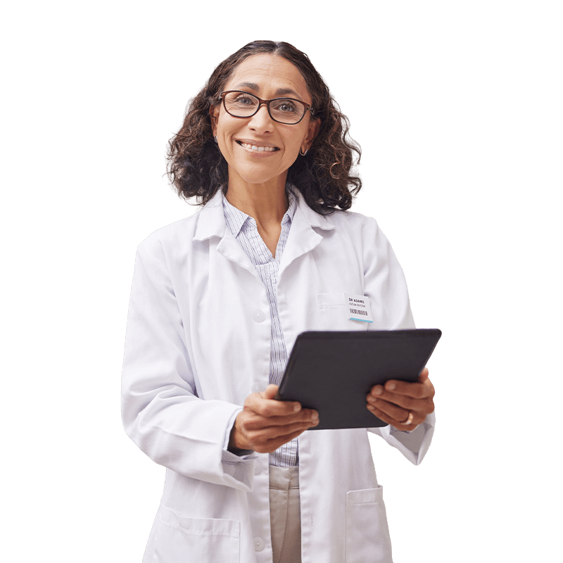 A woman in a lab coat holds a tablet, appearing focused and engaged in her work.
